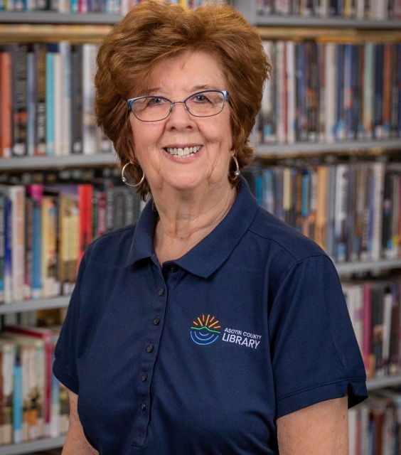 Head shot of Beverly Rhoades in front of book shelves