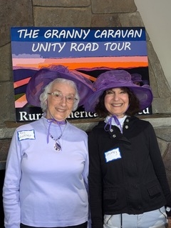 Two women in purple hats with Granny Caravan sign